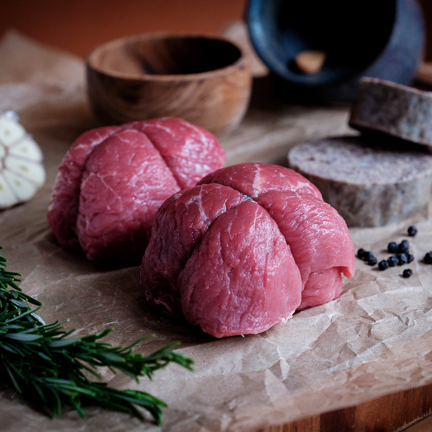 Beef olive on a wooden cutting board with haggis, herbs and spices