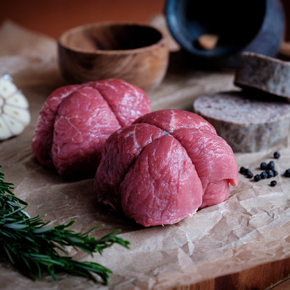 Beef olive on a wooden cutting board with haggis, herbs and spices