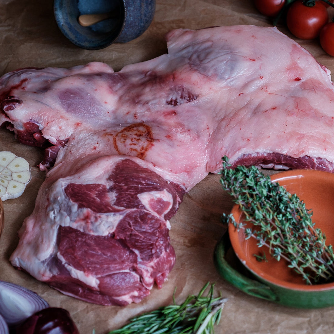 Butterfly Leg of Lamb with herbs and spices on a wooden surface