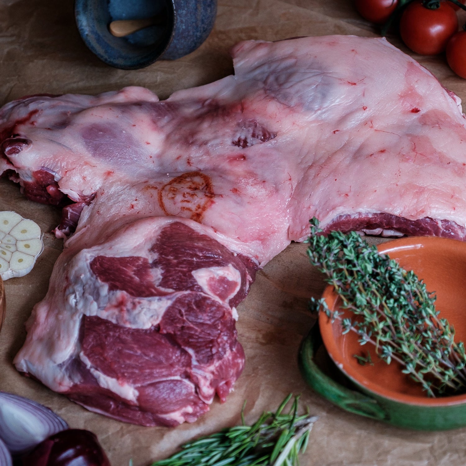 Butterfly Leg of Lamb with herbs and spices on a wooden surface