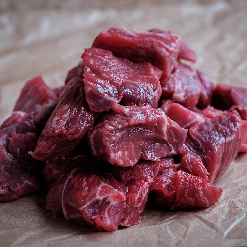Raw beef chunks on crumpled brown paper