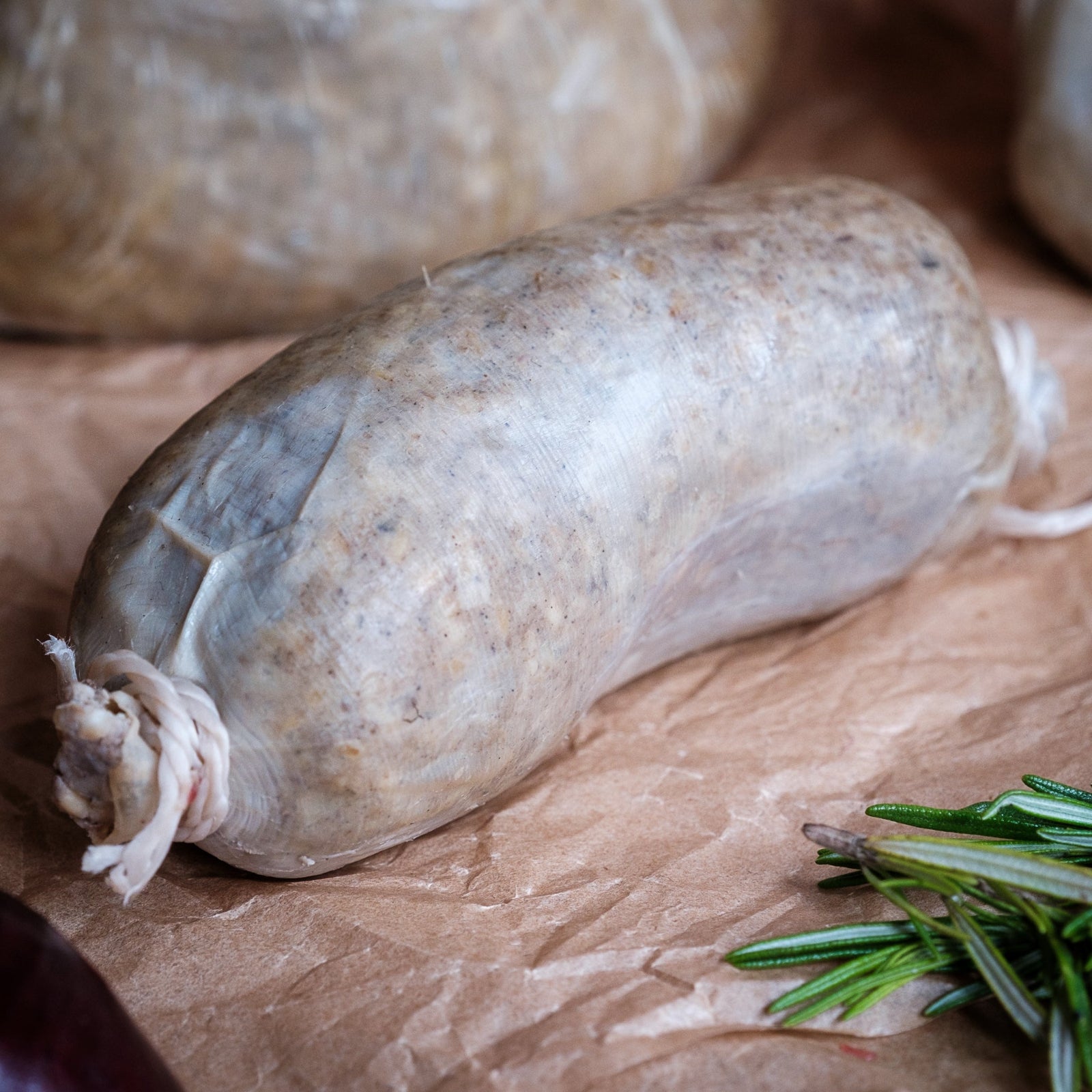 Baby haggis on brown paper with rosemary and a red pepper.