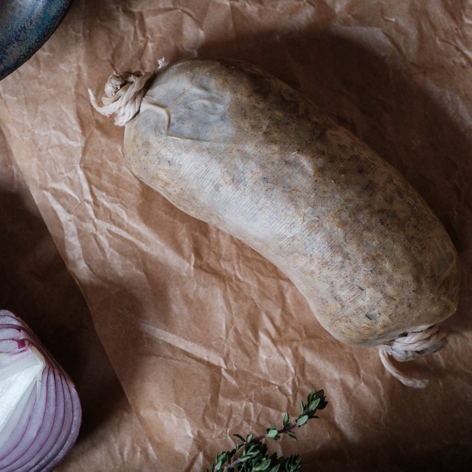 Raw gluten free haggis with red onions and herbs on brown paper