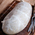 Large Boreray Haggis on a wooden cutting board with a knife and carving tool.