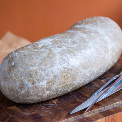 Large Gluten Free Haggis on a wooden cutting board with a knife