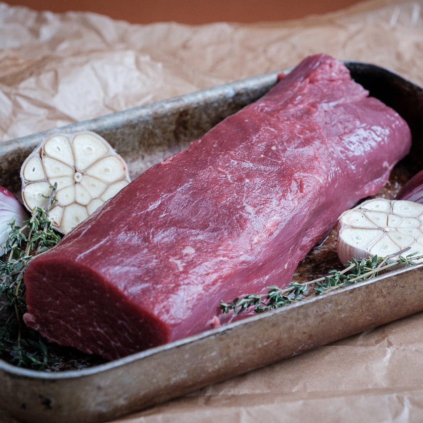 Lardr trim beef fillet with onions and garlic on a baking tray