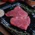 Minute steak on a grill pan with herbs and garlic cloves.
