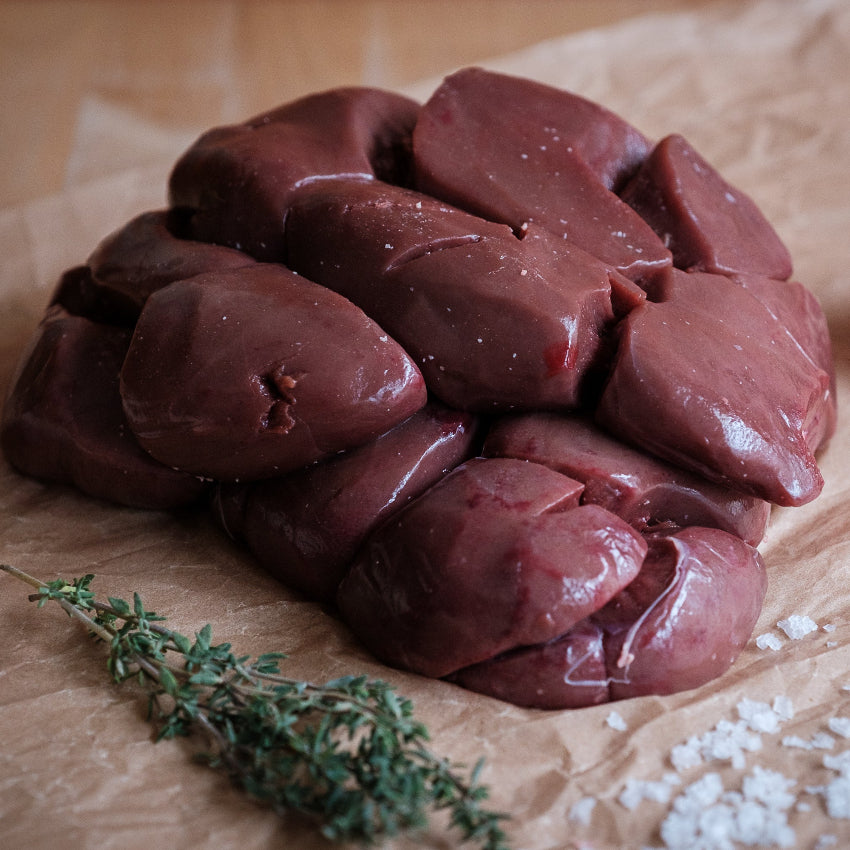 Ox kidney on brown paper with garlic and thyme