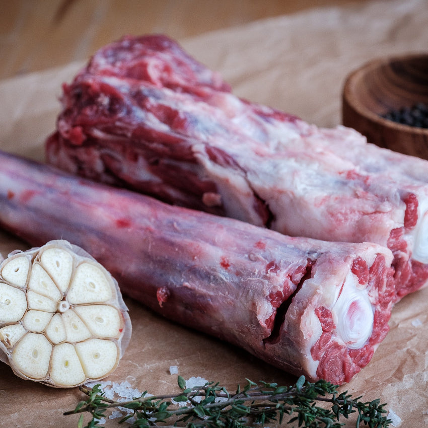 Whole Ox Tail with garlic and thyme on a wooden surface