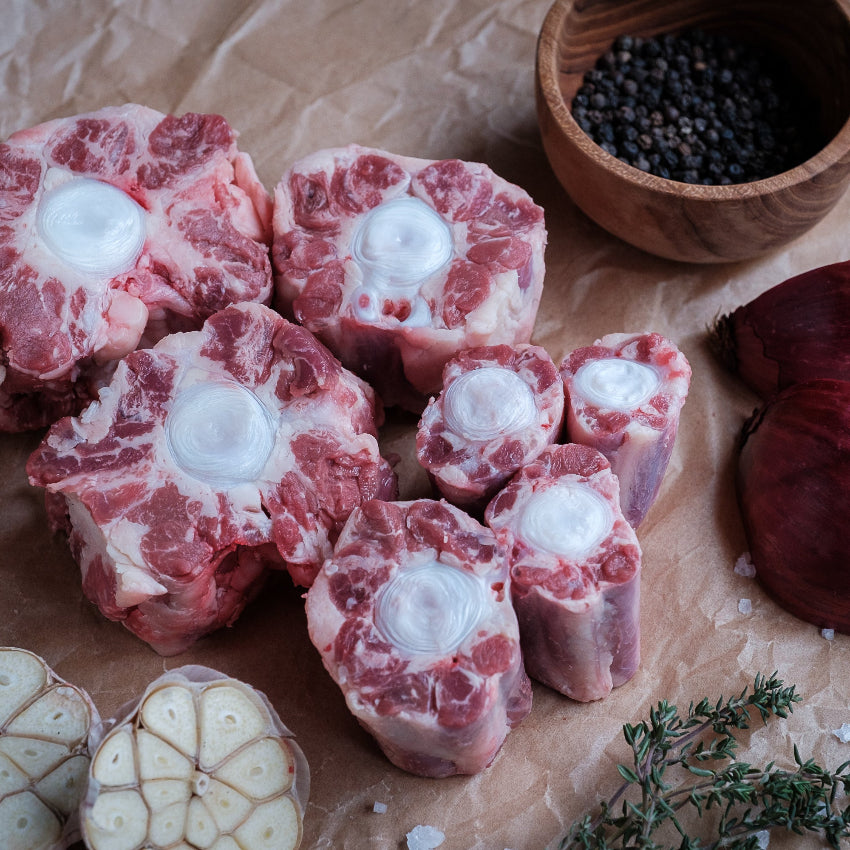 Ox tail portions with onions and herbs on brown paper
