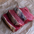 Raw rump steaks on crumpled brown paper
