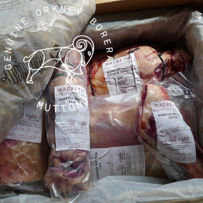 Raw mutton cuts packaged in clear plastic bags with white labels, arranged inside a cardboard box. The packaging has a circular logo and text reading &