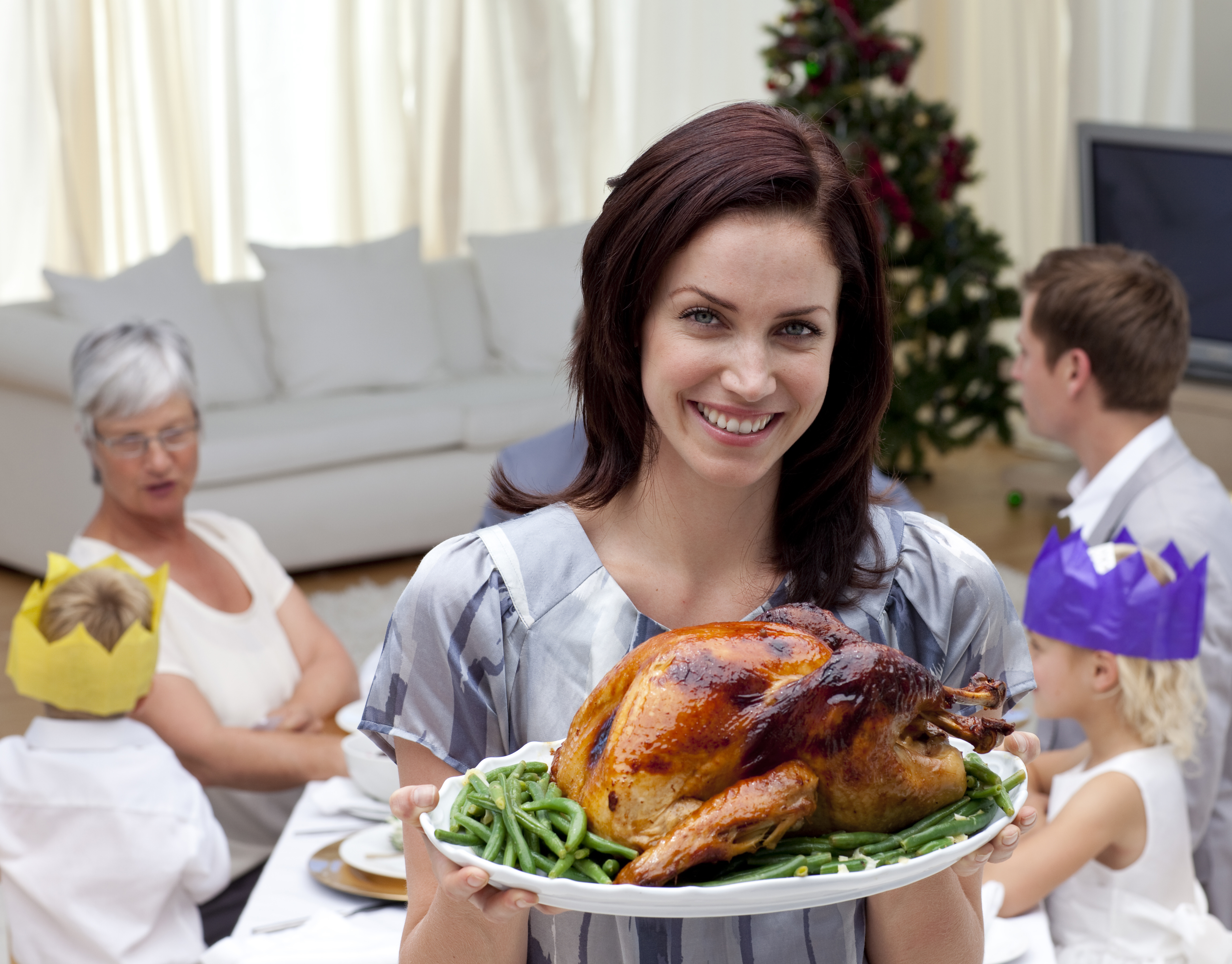 Woman showing Christmas turkey for family dinner at home